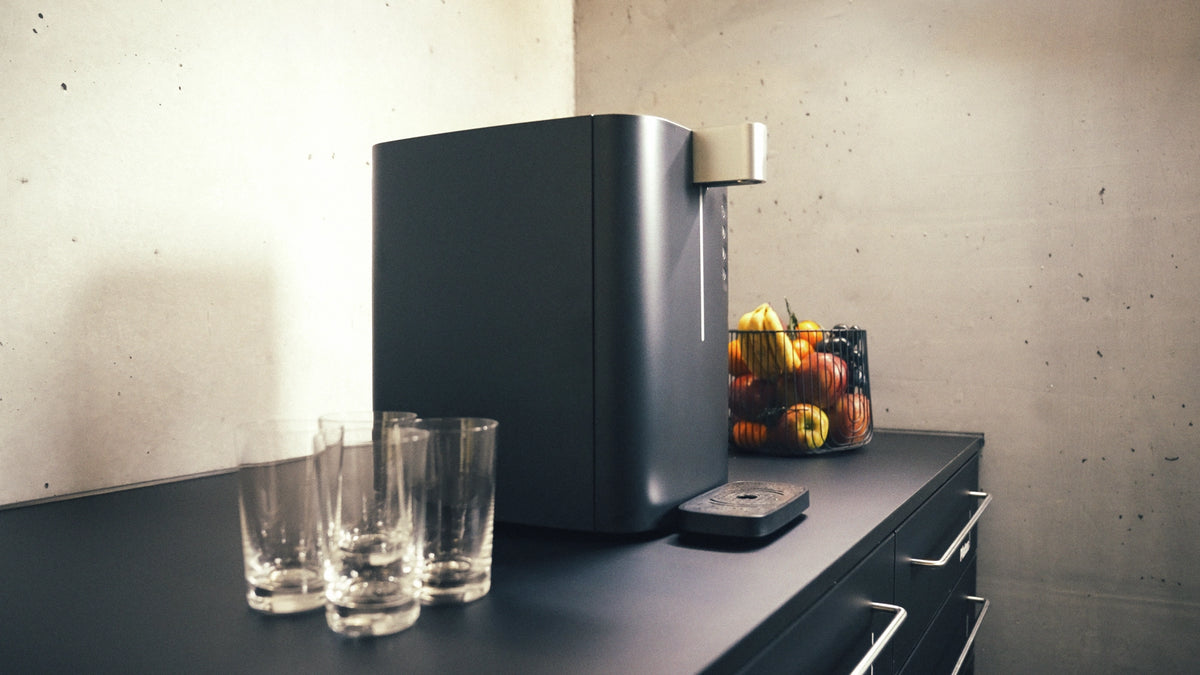 Top Compact standing on a counter to with glasses standing next to it