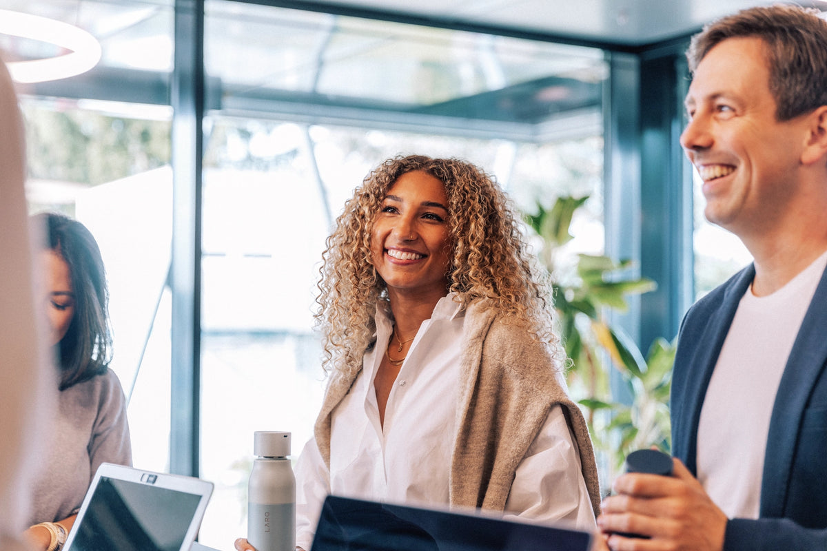 People smiling and interacting in an office setting