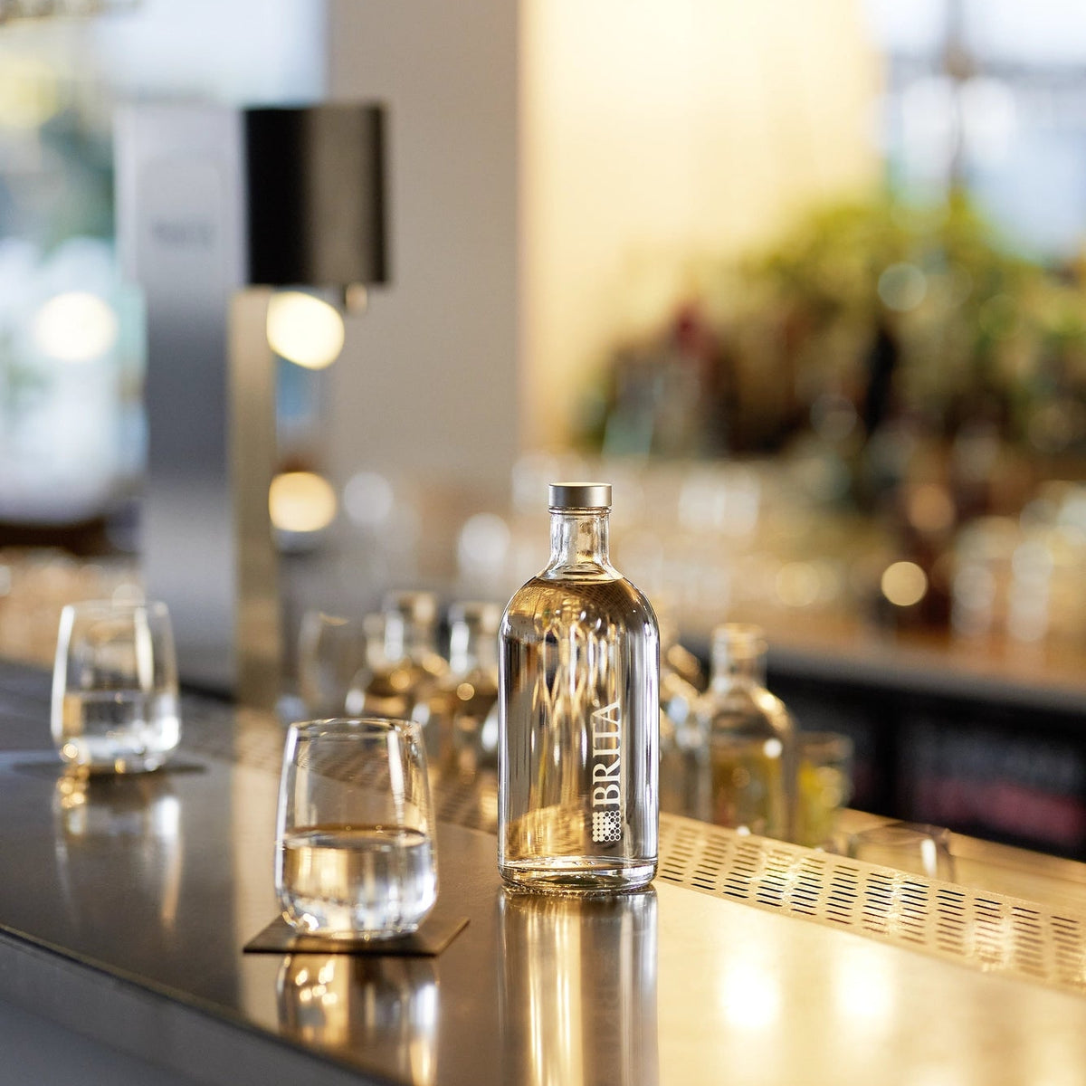 BRITA Bottiglia Lounge su un bancone da bar con bicchieri e un Fill T-Tap sullo sfondo.